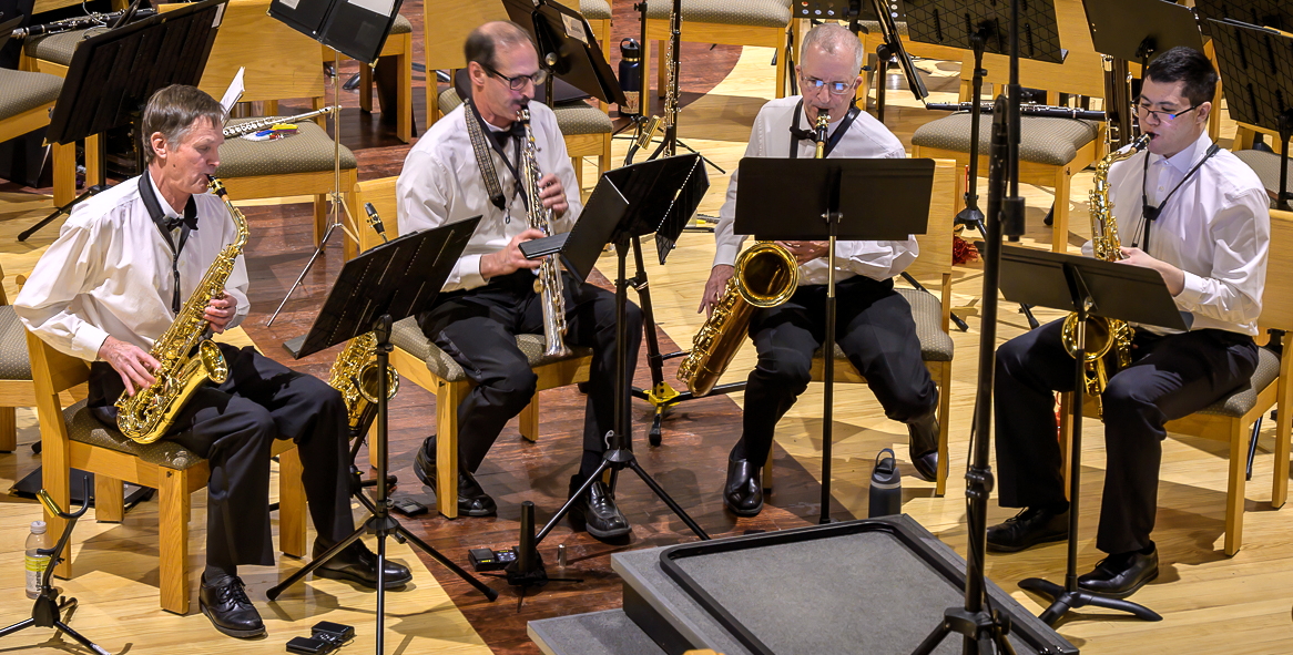 four men holding saxophones